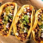 Three tacos with beef mince, chopped onion and salsa on top - Thumbnail Image